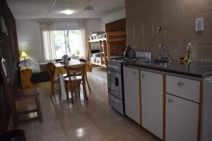 a kitchen with a stove and a table with a dining room at Cabañas El Labriego in Malargüe +18 photos