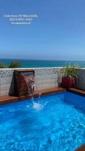 een zwembad met een fontein bij Cobertura R2 Maceió in Maceió