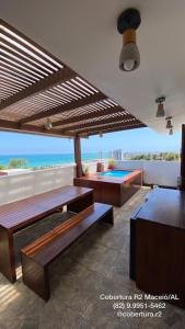 een patio met banken en een zwembad op het dak bij Cobertura R2 Maceió in Maceió