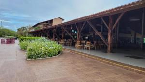 un edificio con mesas, sillas y flores blancas en FLAT HOTEL CANARIUS GRAVATA, en Gravatá