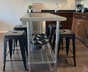 a kitchen table with four stools with pots and pans at Luxury Condo 2 bed 2 bath near Downtown KC in Kansas City