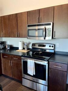 a kitchen with a stove and a microwave at Luxury Condo 2 bed 2 bath near Downtown KC in Kansas City