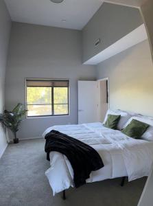 1 dormitorio con 1 cama blanca grande y ventana en Luxury Condo 2 bed 2 bath near Downtown KC, en Kansas City