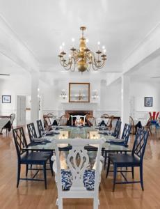 een eetkamer met een tafel en stoelen en een kroonluchter bij Rams Head Inn in Shelter Island