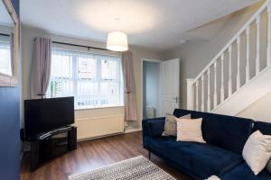 sala de estar con sofá azul y TV en Stylish two bedroom home SHEFFIELD, en Sheffield