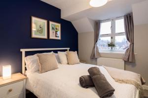 - une chambre avec un lit blanc et un mur bleu dans l'établissement Stylish two bedroom home SHEFFIELD, à Sheffield