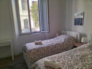 a room with two beds and a window at Appartamento Hygge incantevole in Reggio di Calabria
