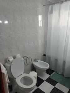 a bathroom with a white toilet and a bidet at Casa Caleta Caballo in Caleta de Caballo