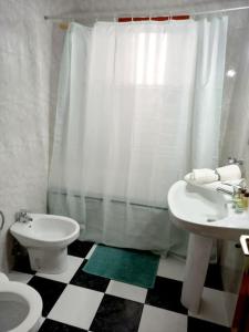 a bathroom with a black and white checkered floor at Casa Caleta Caballo in Caleta de Caballo