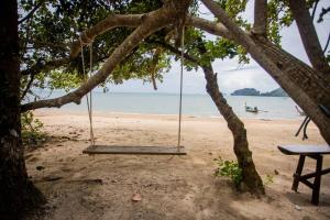 un'altalena appesa ad un albero su una spiaggia di VILLA LOVED BEACH AO NAM MAO krabi ad Ao Nam Mao