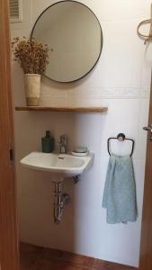 een badkamer met een wastafel en een spiegel aan de muur bij Casa La Hojiblanca in Mancha Real