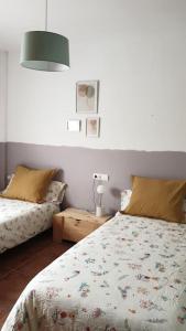 een slaapkamer met 2 bedden en een lamp op een tafel bij Casa La Hojiblanca in Mancha Real