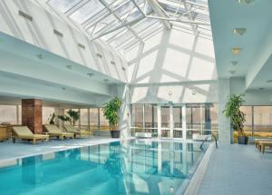 una piscina en un edificio con techo de cristal en Hotel Korston Tower Kazan, en Kazán