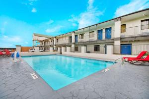 a swimming pool in front of a building at Studio 6 - Texas City, TX in Texas City