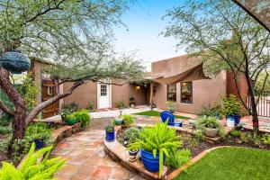 a home with a garden with potted plants at Historic Guard House in Tucson