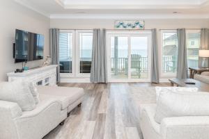 een woonkamer met een bank en een tv bij Villas View in North Topsail Beach