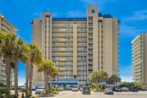 een hoog gebouw met palmbomen op een parkeerplaats bij Bluewater 1504 in Orange Beach