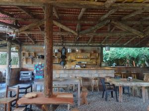 a room with tables and chairs and a kitchen at hospedaje rural finca cafetera La Maloka in Jardin