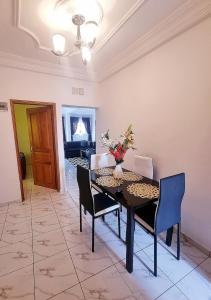 a dining room with a table and chairs at Résidence Sighaka - Suite Royale - WiFi, Gardien, Parking in Douala