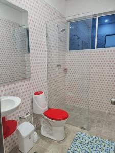 a bathroom with a red toilet and a sink at La Higuera, Casa Campestre. in El Asilo