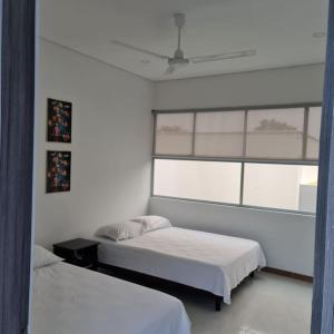 a bedroom with two beds and a window at La Higuera, Casa Campestre. in El Asilo +20 photos