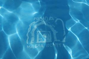 a sign in the water in a swimming pool at Pousada Maria Bonita in Macacos