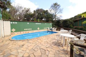 a patio with a pool and chairs and a table at Pousada Maria Bonita in Macacos