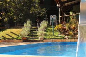 a swimming pool in a yard with a water fountain at Pousada Maria Bonita in Macacos