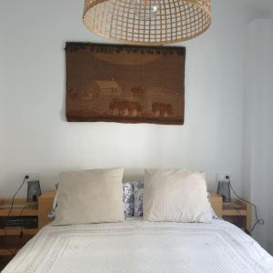 1 dormitorio con 1 cama con una pintura en la pared en Bonito apartamento en el casco antiguo, en Jaén