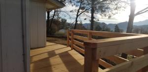 een houten terras met een bank op een huis bij Panoramic Lake View, Lake Isabella in Wofford Heights