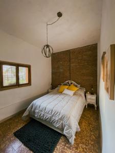 1 dormitorio con 1 cama grande y cabecero de madera en Inti, hospedaje de campo. en Arrecifes