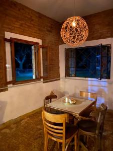 comedor con mesa, sillas y lámpara de araña en Inti, hospedaje de campo. en Arrecifes