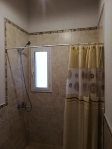 y baño con ducha y cortina de ducha. en Casa de Montaña en Yacanto
