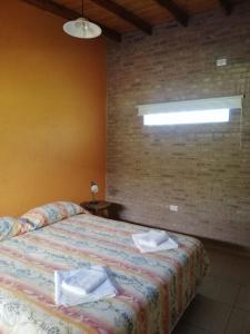 una camera da letto con un letto e asciugamani di Casa de Montaña a Yacanto