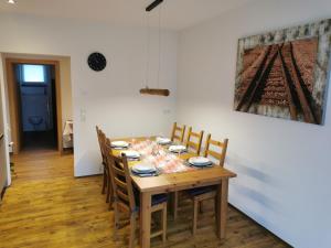 een eettafel met stoelen en een schilderij aan de muur bij Apart Emilia in Schönwies