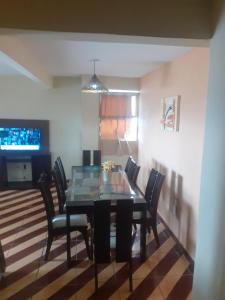 a dining room with a glass table and chairs at Apartamento Confortável na Zona Norte in Rio de Janeiro