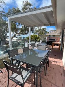 a patio with a table and chairs on a deck at Bayview at Callala in Callala Bay