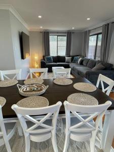 a living room with a table and white chairs at Bayview at Callala in Callala Bay