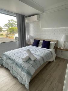 a bedroom with a bed with two stuffed animals on it at Bayview at Callala in Callala Bay