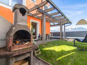 an outdoor pizza oven in a yard with a patio at Sonnenwinkel II in Kolsassberg