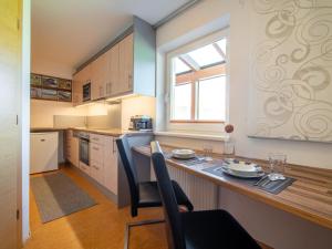 una cucina con tavolo, sedie e finestra di Sonnenwinkel II a Kolsassberg