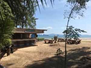 un edificio sulla spiaggia con tavoli da picnic di Koh Yao Noi Beach Resort a Ko Yao Noi