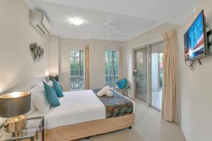 a bedroom with a bed and a tv on a wall at The Lakes Resort Cairns in Cairns +73 photos