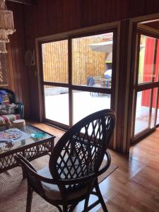 a living room with a chair and a glass table at La Casa Roja Cerro Azul in Cerro Azul