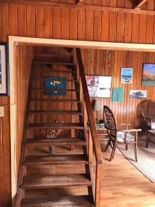 eine Holztreppe in einem Zimmer mit einem Tisch und Stühlen in der Unterkunft La Casa Roja Cerro Azul in Cerro Azul