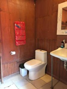 bagno con servizi igienici bianchi e lavandino di La Casa Roja Cerro Azul a Cerro Azul