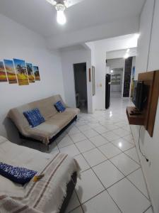 a living room with two beds and a tv at APARTAMENTO COQUEIROS A 1 QUADRA DO MAR in Guaratuba