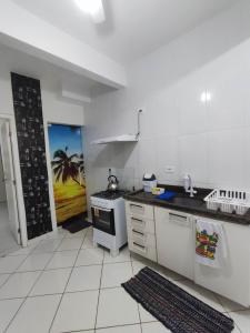 a kitchen with a sink and a stove at APARTAMENTO COQUEIROS A 1 QUADRA DO MAR in Guaratuba