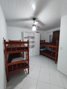 a room with two bunk beds and a ceiling at APARTAMENTO COQUEIROS A 1 QUADRA DO MAR in Guaratuba