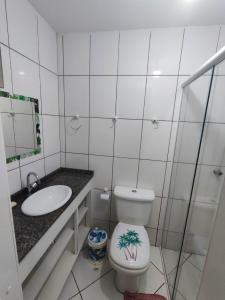 a bathroom with a toilet and a sink at APARTAMENTO COQUEIROS A 1 QUADRA DO MAR in Guaratuba
